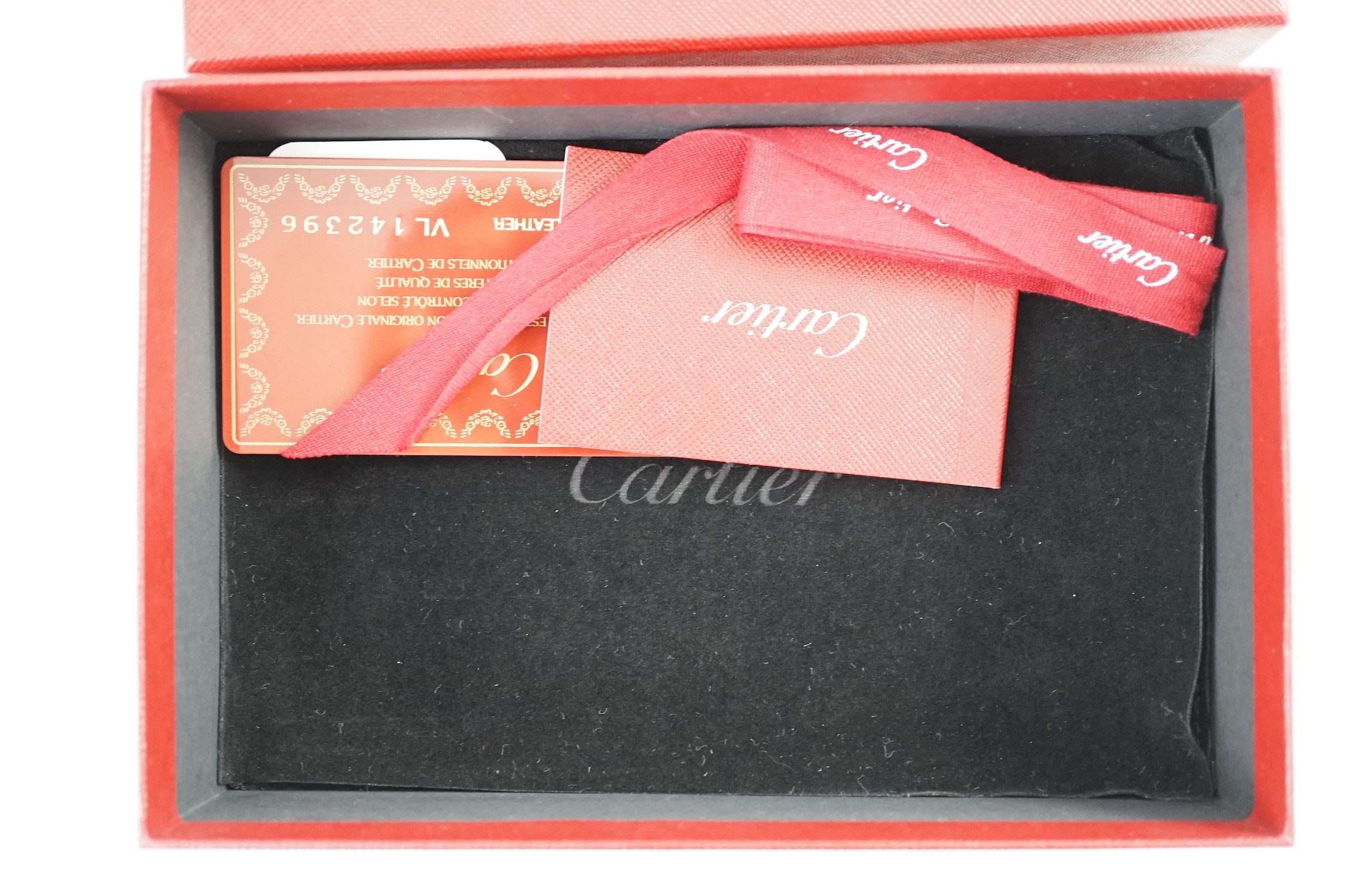 A Cartier red leather notebook, boxed, with bag, papers and certificate